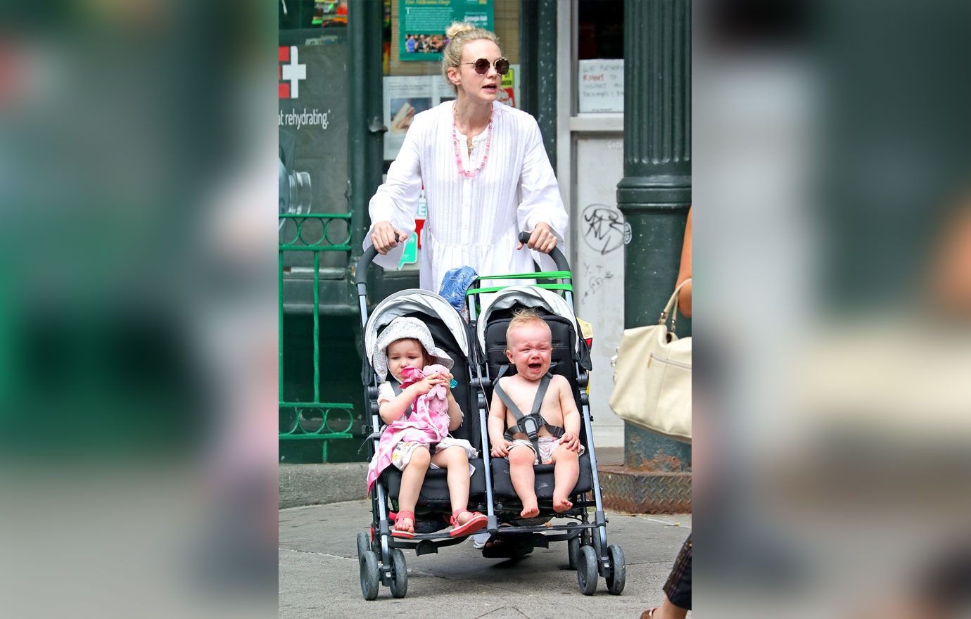 Carey Mulligan carrying her children in strollers during an outing