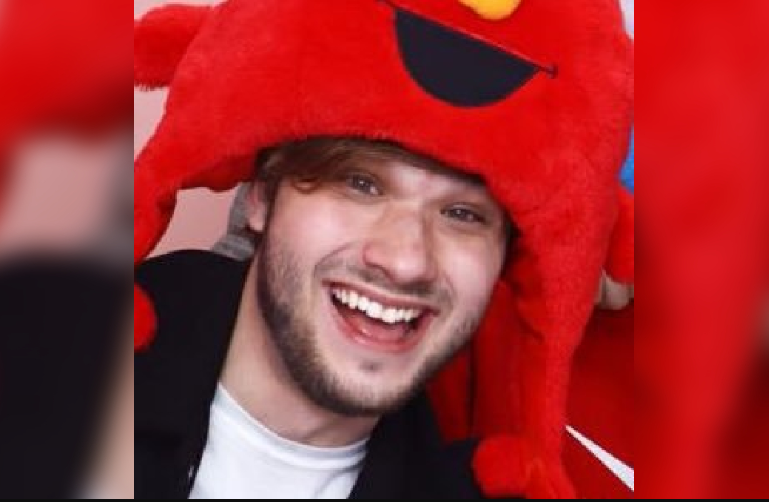 CookieLoL wearing a red stuffed toy cap. 