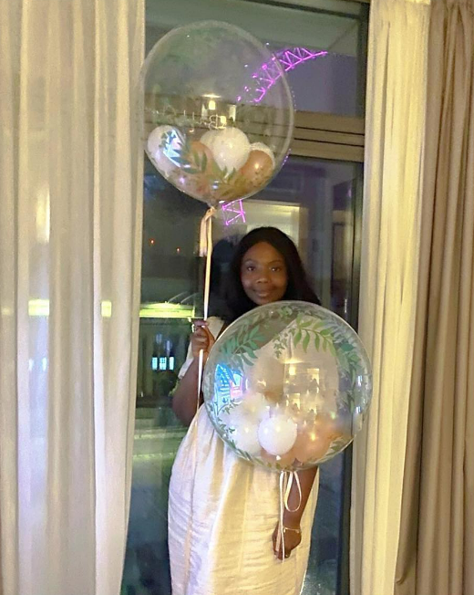 Mimi Ndiweni poses for a picture smilingly holding a balloon