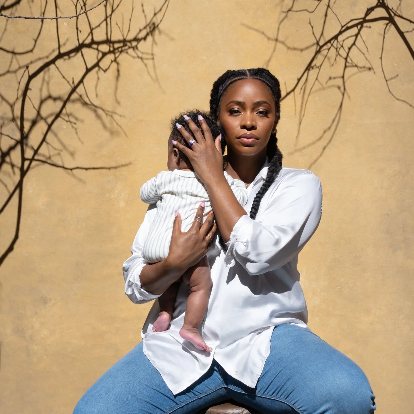 Teyonah Parris holding her daughter during photoshoot for Ebony Magazine
